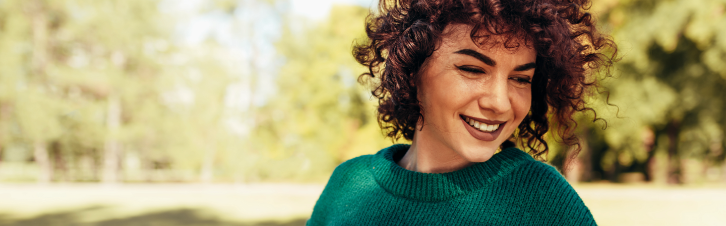 Woman in a green jumper walking in the outdoors