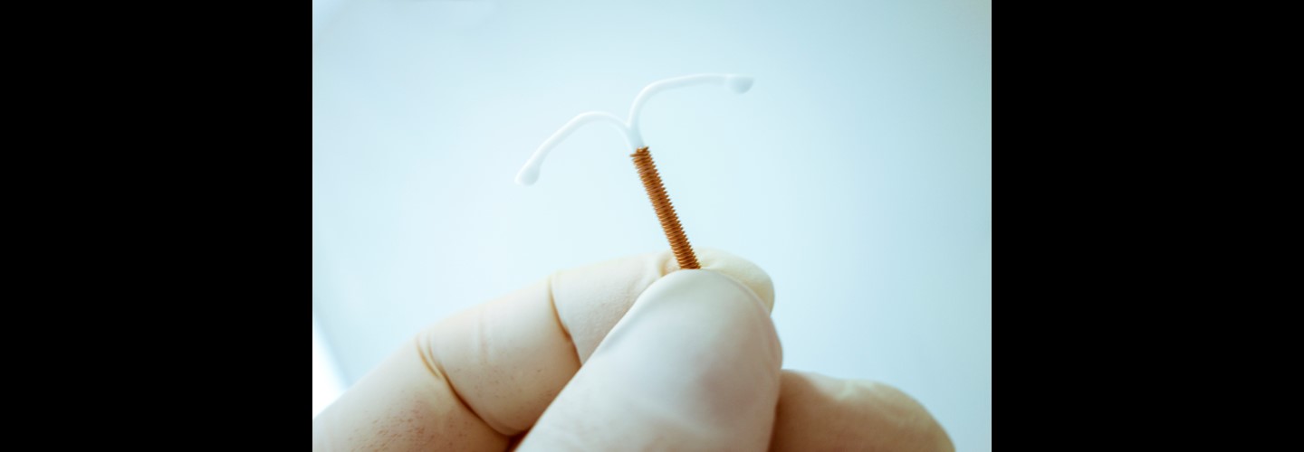 a person holding up an IUD emergency contraceptive
