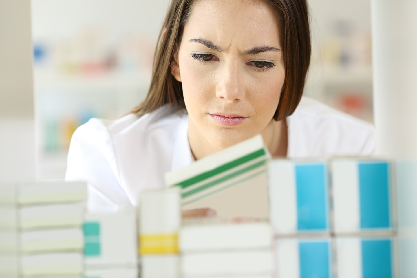 a woman checks the expiration date on a box of pills.