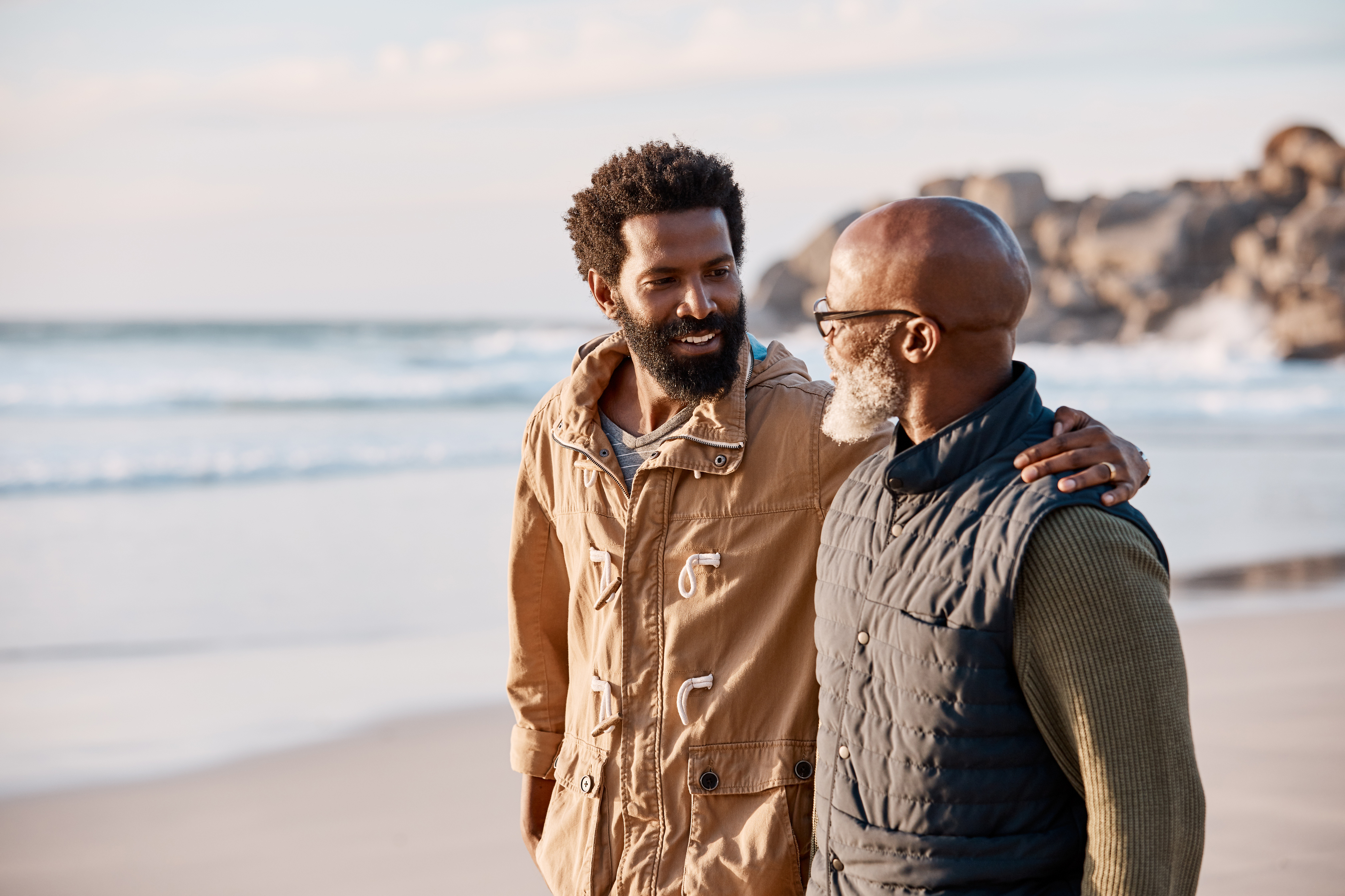 a man walking on the beach with his dad